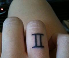 Tatuaje de geminis en el dedo