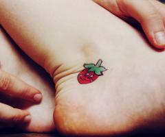 Tatuagem feminina delicada morango no pe
