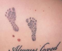 Tatuaje de piecitos de bebe en la espalda