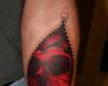 Tatuaje de calavera roja con cierre en el antebrazo