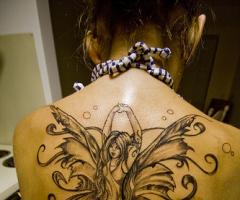 Beautiful large fairy tattoo on her upper back