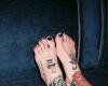 pies tatuados con rosas y simbolos