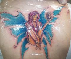 Hada sentada con alas abiertas
