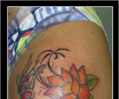 Tatuagem borboleta e flor de lótus no braço