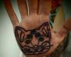 Tatuaje de lineas de rostro de gato en la palma de la mano