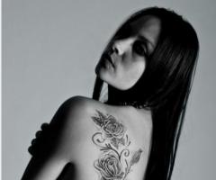 Long vine with hanging roses inked all across the side back
