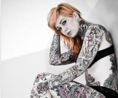 Displaying many old school tattoos, which are inked all over her body