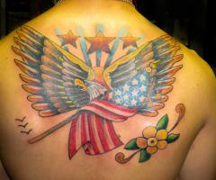 Patriotism expressed with Bald Eagle with the flag tattooed on upper back
