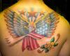 Patriotism expressed with Bald Eagle with the flag tattooed on upper back