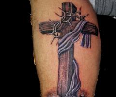 Wooden Cross with thorny vines across it reminding of the great sacrifice by the Savior