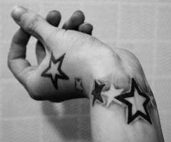 Bright and bold stars done partly on wrist and partly on the hand