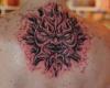 Scary, devilish face of a stone sun tattoo