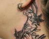 Behind the ear design of a name tattoo paired with a vine of flowers