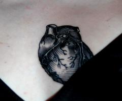Black, ash-like anatomical heart tattoo inked on chest