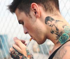 Tatuagem de homem no braço e pescoço