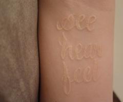 White tattoo ink on black skin