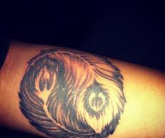 Yin and yang with feathers tattoo