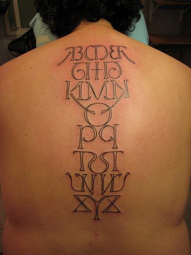 Tatuaje de abecedario en la espalda