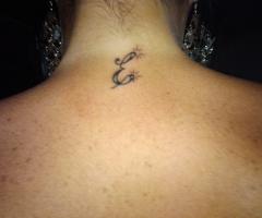 Tatuaje de inicial E en la nuca