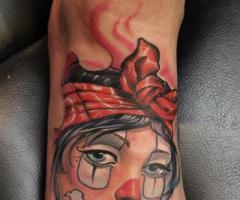 Tatuaje de mujer payaso en el pie