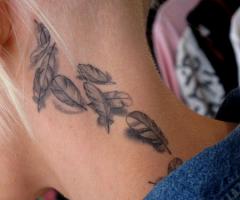 Tatuaje de plumas en la nuca