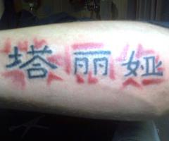Letras chinas en el brazo con sombra roja