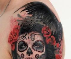 La catrina entre flores rojas y alas de pajaros