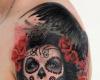 La catrina entre flores rojas y alas de pajaros