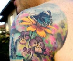 Varias flores y mariposa en brazo completo