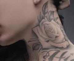 Tatuajes blanco y negro de rosas en el cuello