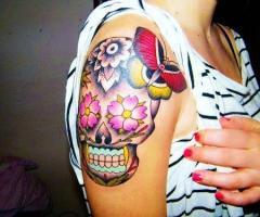 Tatuaje femenino de calavera en el brazo