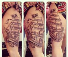 Tatuajes de barcos en la pierna de una mujer