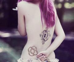 Tatuaje de cerradura en espalda