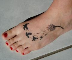 Tatuaggio di uccelli e di tarassaco nel piede