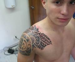 Tatuaje masculino en el hombro estilo maori