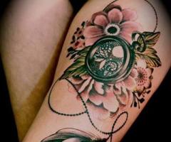 Feather, flowers and click on leg tattoo