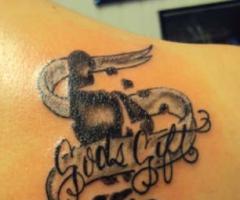 Tatuaje de pie de hijo decorado con una cinta