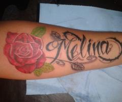 Tatuaje de rosa y nombre melina