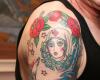 Rose e altri disegni del tatuaggio sulla spalla