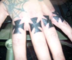 Tatuaggi spider e croci sulle nocche e dita
