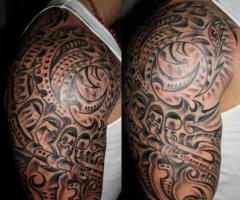 Impressionante tatuaggio shader con dettagli in rosso sul braccio