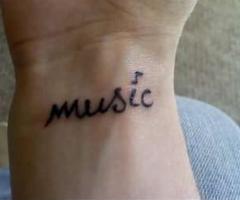 Tatouage au poignet simple avec le mot musique