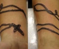 Tatouage original sur le poignet simulant un enchevêtrement chapelet