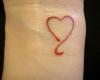 Simple tatouage sur le poignet avec un coeur rouge