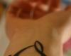 Tatouage sur le poignet de symboles musicaux formant un coeur