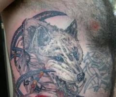 Tatouage loup sur le côté avec plusieurs figures autour