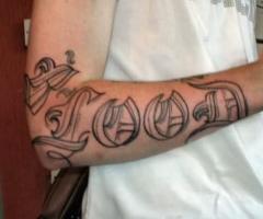 Tatouage sur le bras avec un grand mot