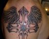 Schöne Tattoo auf dem Arm eines Kreuzes mit zwei Engelsflügeln
