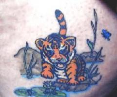 Lustige Tattoo von einem Tiger Cub spielen im Wasser