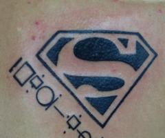 Tatuaje de superman y letras kriptonianas